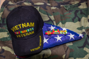 Vietnam Veteran Cap, Ribbons & American Flag On Camouflage Uniform