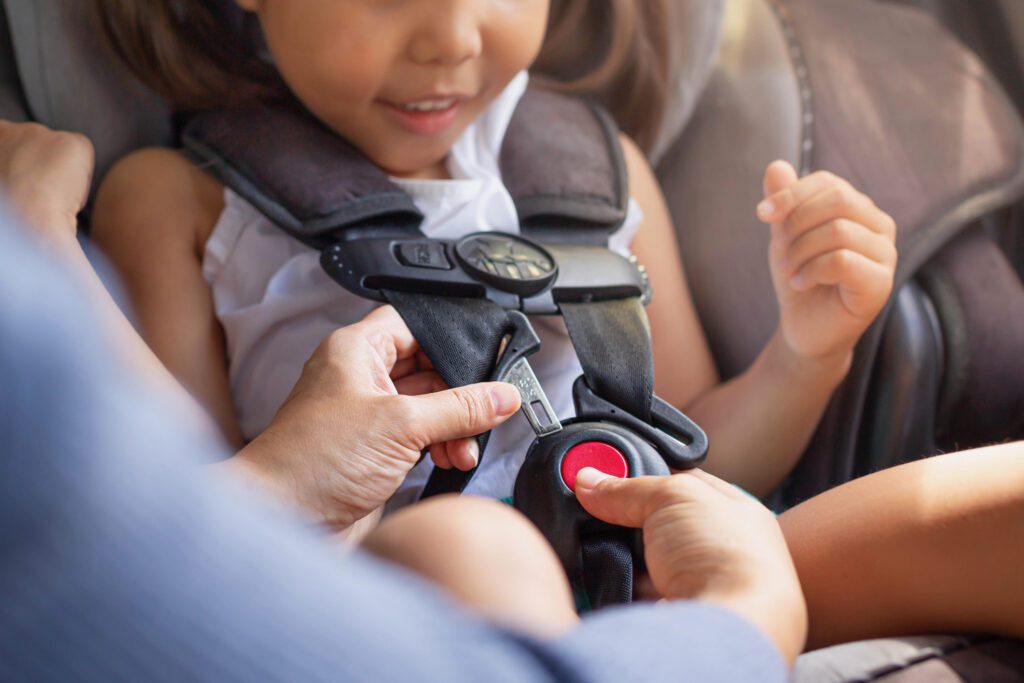 A child securely seated in a car seat, fastened with a child's safety belt for protection during travel.
