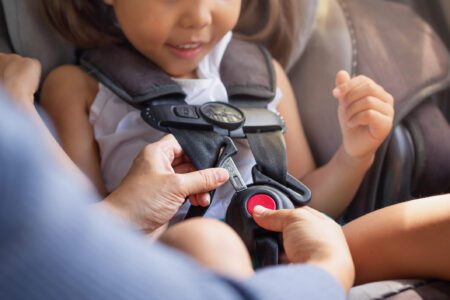 A child securely seated in a car seat, fastened with a child's safety belt for protection during travel.