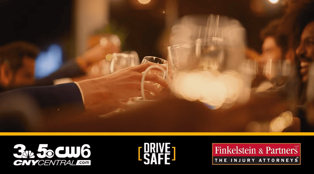 Hands raising wine glasses at a blurred evening gathering; logos for CNYCENTRAL.com, DRIVE SAFE, and Finkelstein & Partners The Injury Attorneys