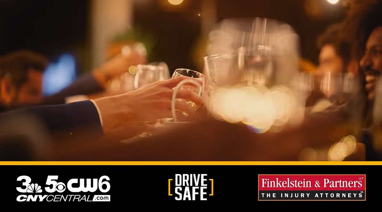 Hands raising wine glasses at a blurred evening gathering; logos for CNYCENTRAL.com, DRIVE SAFE, and Finkelstein & Partners The Injury Attorneys